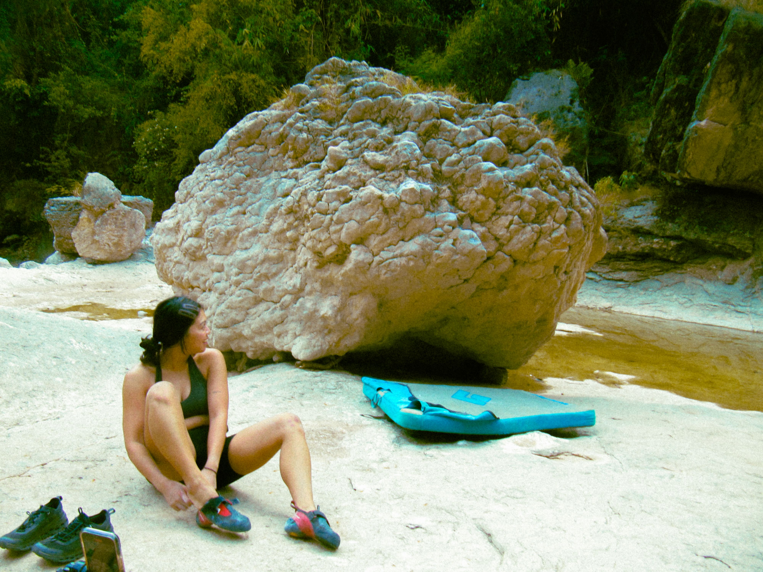 climber putting on shoes preparing to climb a boulder-min